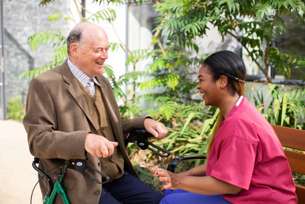 An image of a young nursing home employee with a resident